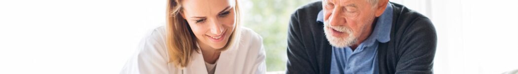 A caregiver reviews the daily routine with her elderly client over a cup of coffee.